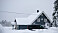 Makarna Jemtlands mörkblå hus omgivet av snö.