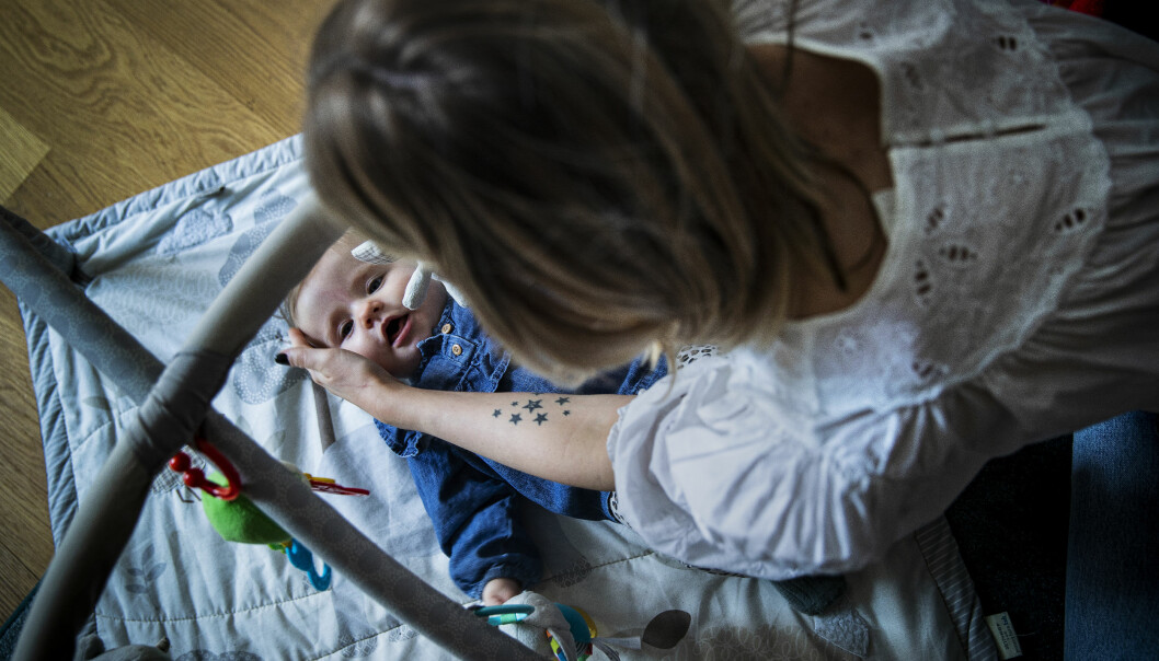 Malin Lundberg Emilsson tillsammans med dottern Maj som ligger på golvet i ett babygym.