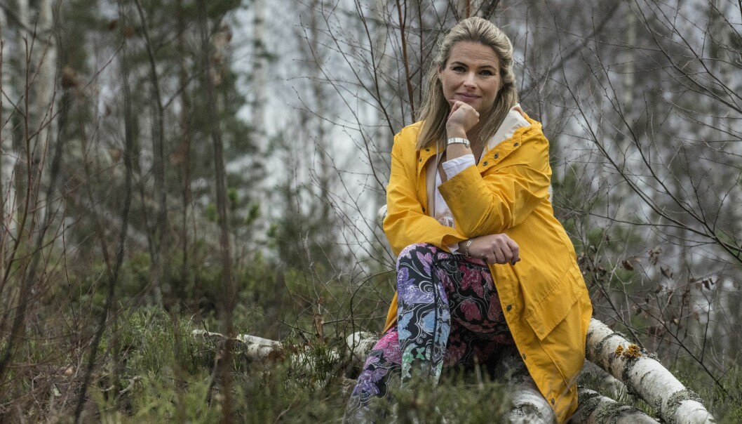 Kvinna sitter i skogen, det hjälper henne att komma ner i varv.