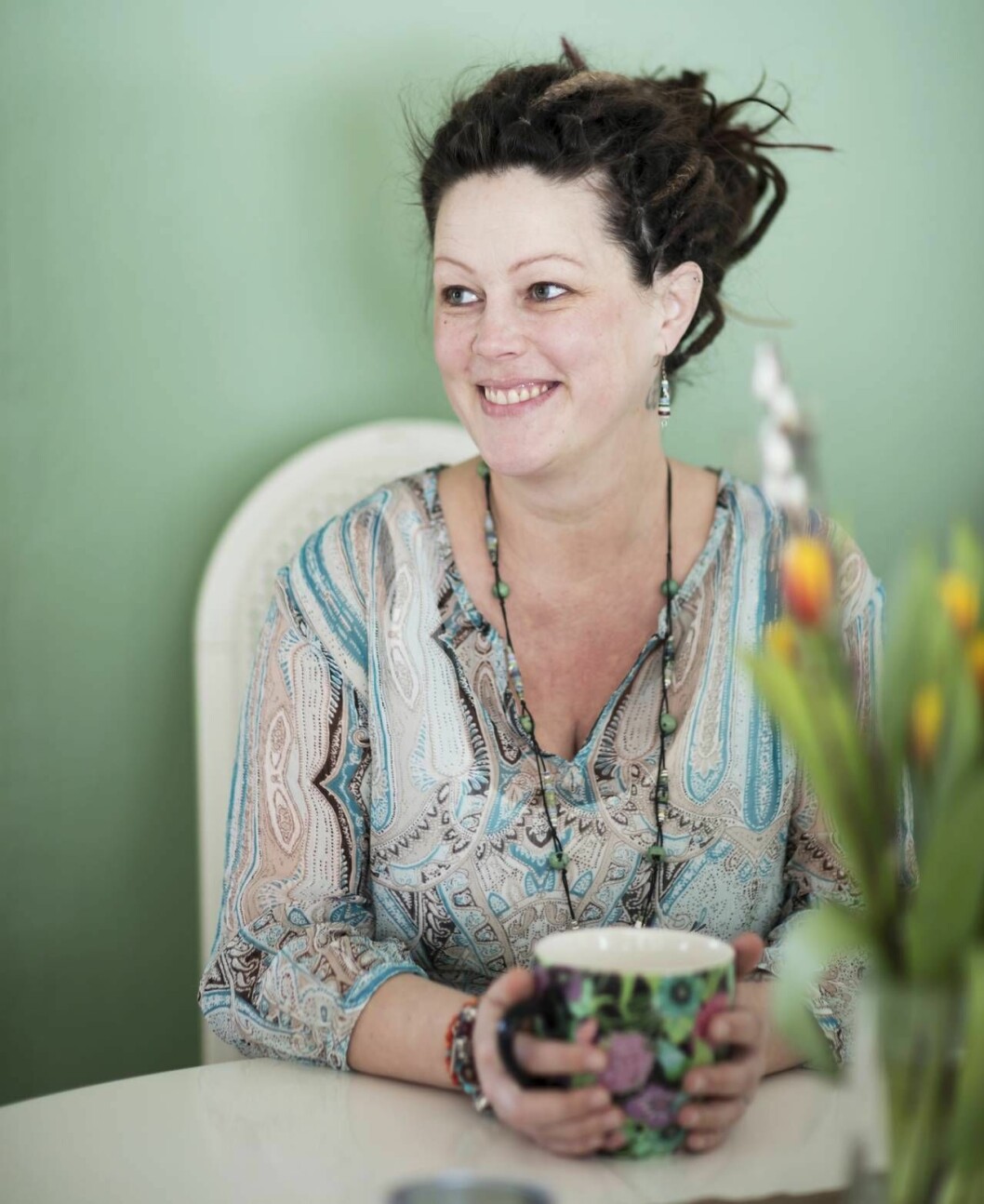 Maria Viklund arbetar hårt för att må så bra hon kan, genom acceptans, yoga och rätt kost. Foto: Carola Harnesk Maria sitter med en kaffemugg