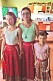 En medelålders kvinna står i typiskt rumänska kläder med sina två döttrar.