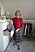 Oldfluencern Maria Sörensson i röd tröja och rutig kjol i sin klädkammare hemma i Lund.