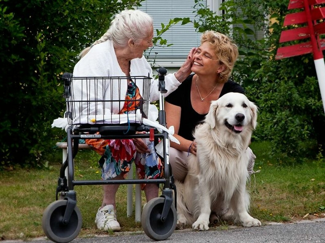 Maria har jobbat tillsammans med sin vårdhund Oliver under nästan hela sjukdomstiden. Här hälsar de på Åse på ett äldreboende. Maria och hennes hund Oliver hälsar på ett äldreboende