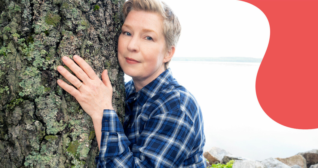Mariette Glodeck håller om ett träd och tittar in i kameran