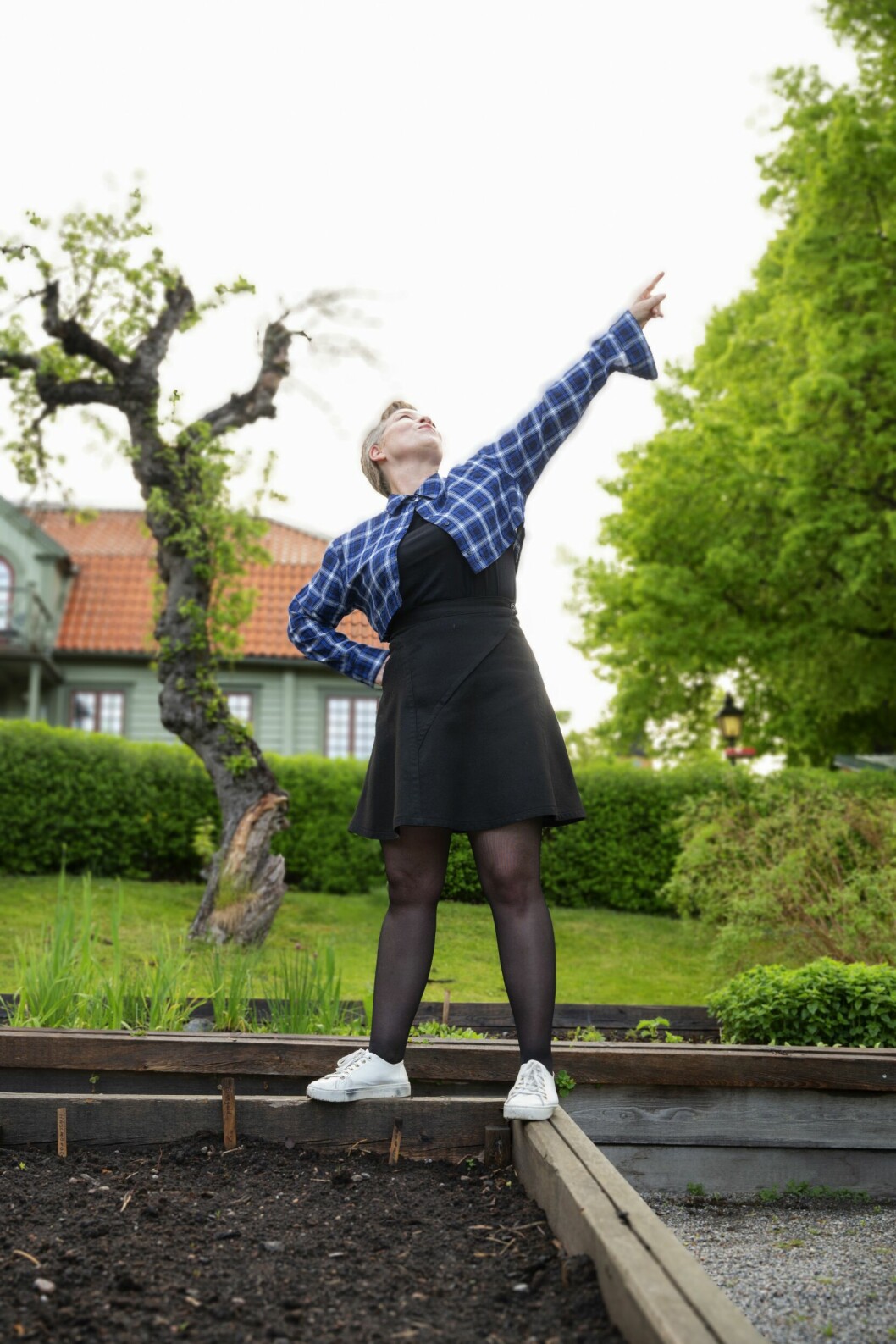Mariette Glodeck gör en pose vid odlingslådorna i trädgården.