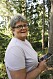 Geocaching-entusiasten Marinette Olsson ute i skogen med mobilen i högsta hugg.
