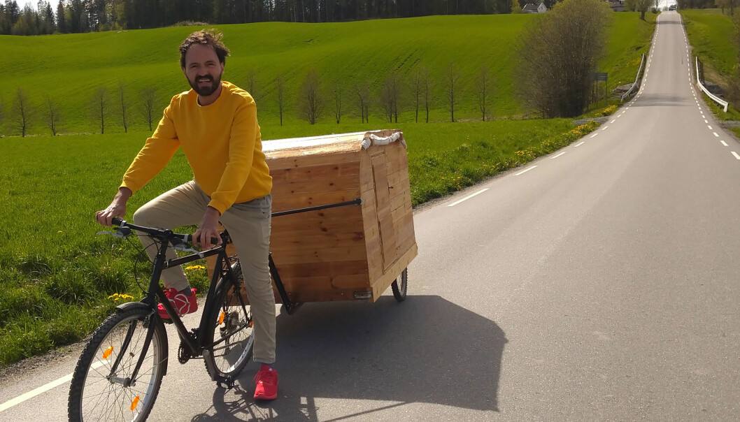 Mario Andrade cyklar med sin hemmabyggda cykelhusvagn.