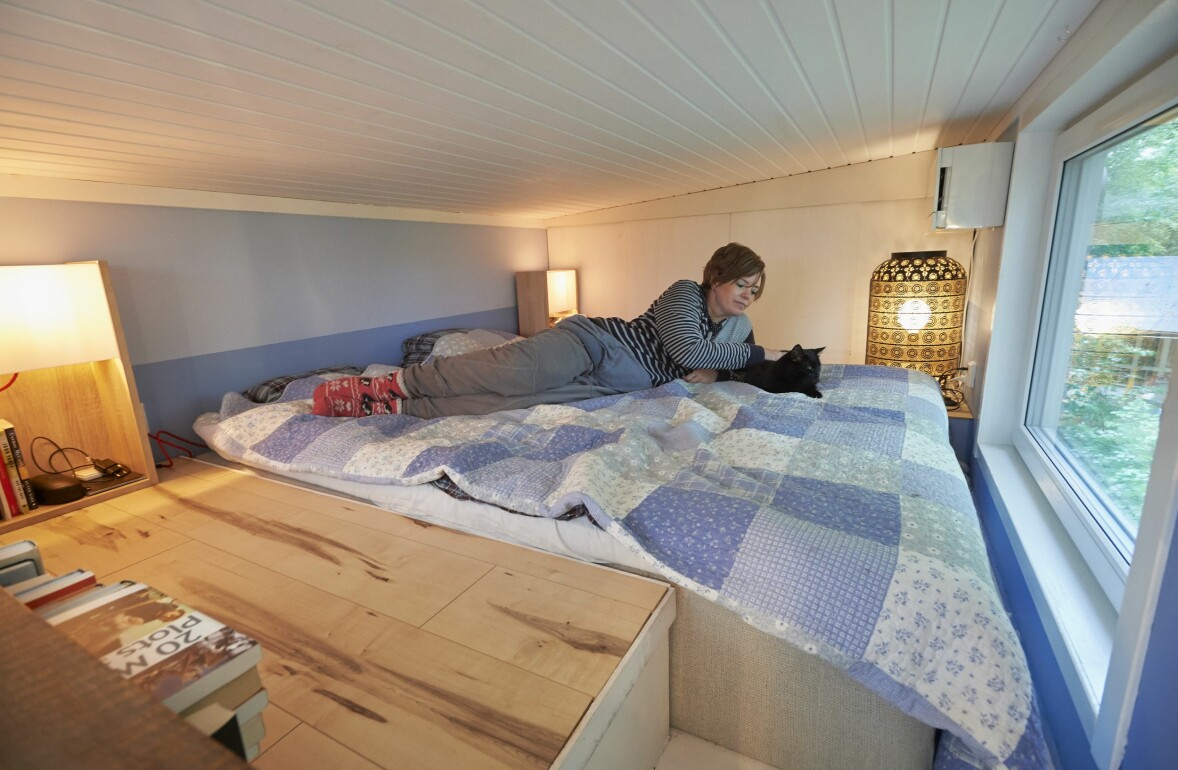 Sovloftet är takhöjden är 1,45 meter. Marita ligger på sängen i sovloftet tillsammans med en av katterna.