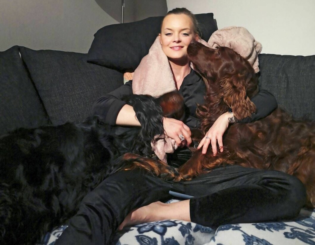 Matilda pustar ut efter operationen i Barcelona. Matilda myser i soffan med två hundar