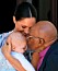 Desmond Tutu pussar Archie på pannan medan mamma Meghan nöjt ser på.