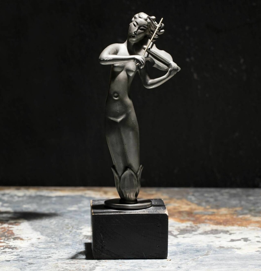 Violinisten i tenn från Ystad Metall är ett exempel på den högklassiga formgivning som metallföretaget i södra Sverige kunde erbjuda. Skulpturen är ostämplad men tiden bör vara 1930-tal. Värdet ligger på ett par tusen kronor trots en skada. Ostämplad skulptur från Ystad metall