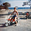 Micke som ung sitter på en moped i linne och shorts och i bakgrunden syns havet.