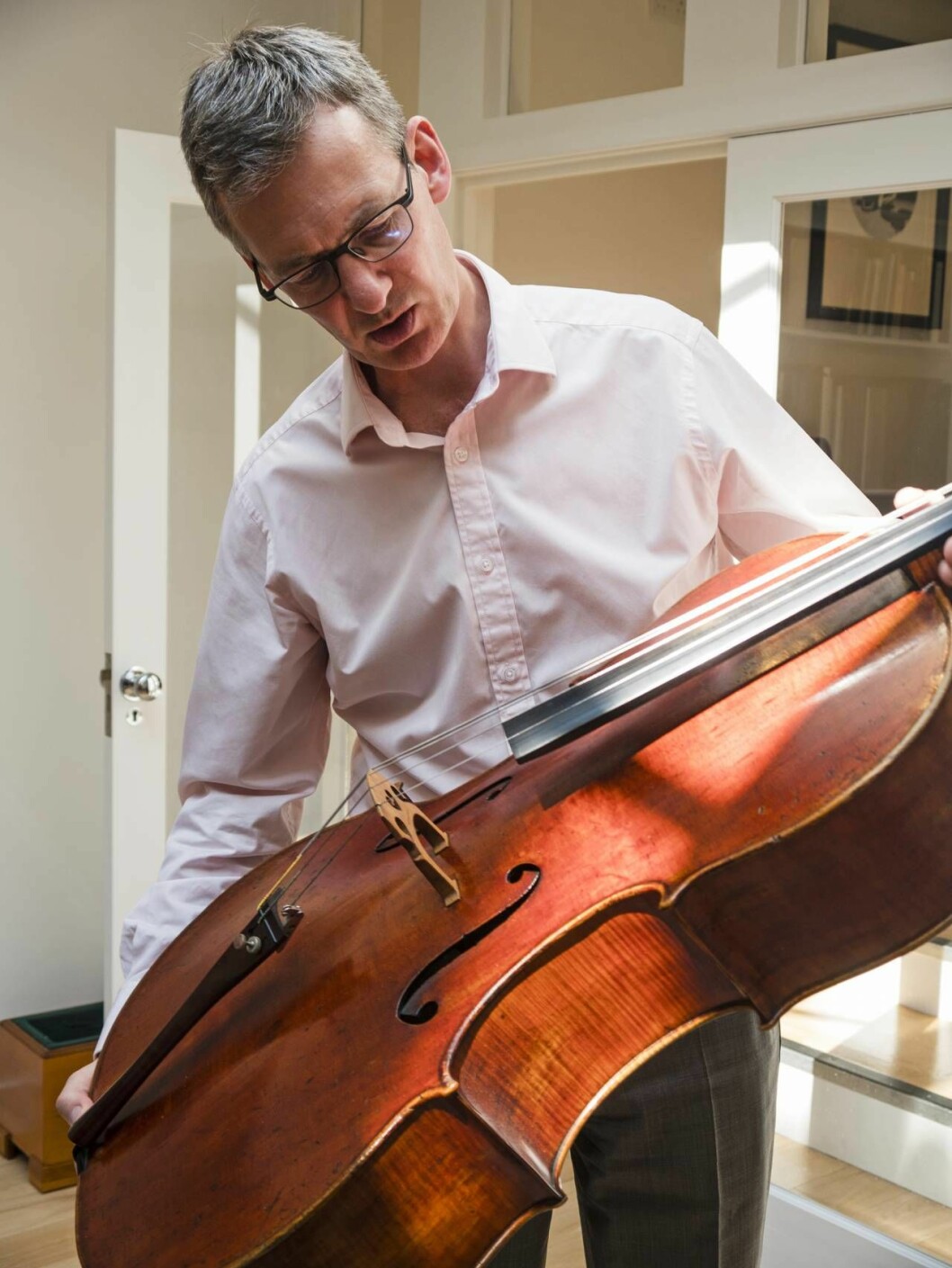 ”Tänk att en så komplicerad sak som en violin eller cello i dag byggs med samma teknik som för 300 år sedan. Det har nästan inte behövts någon teknisk utveckling sedan dess, vilket ju är helt otroligt”, säger auktionsförrättaren Tim Ingles. auktionsförrättaren Tim Ingles med ett instrument