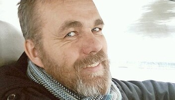 Närbild på en glad Svein Jemtland med skägg, som kör bil, privatfoto från tidigare.