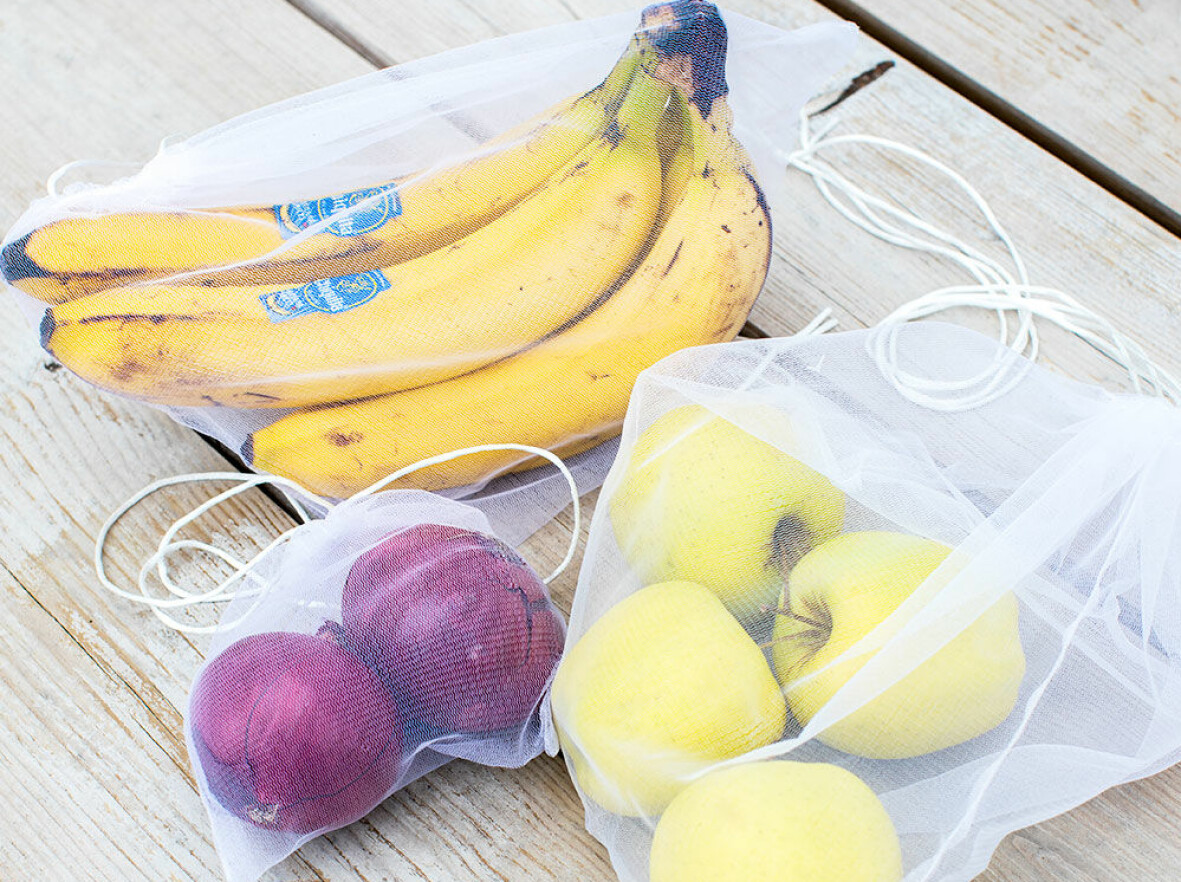 Nätpåsar med frukt och grönsaker i.