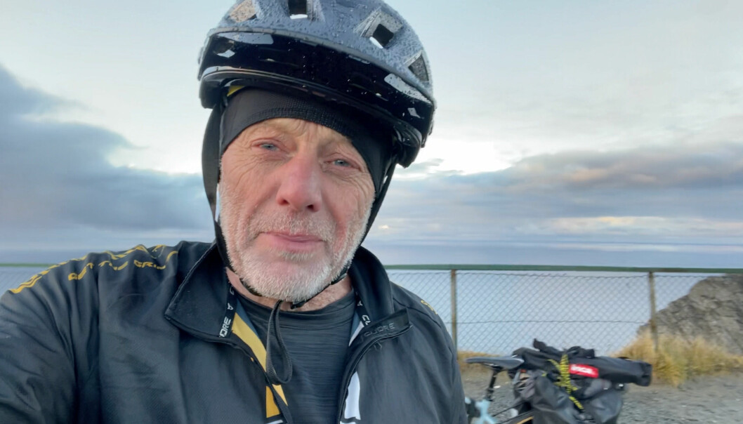 – Lyckligtvis har jag en fru som förstår mig och som stöttar mig helhjärtat. Annars hade det aldrig gått, säger Nick. Här på Nordkap, Norge. Nick Sanders har på sig en svart cykelhjälm, i Nordkap, Norge.