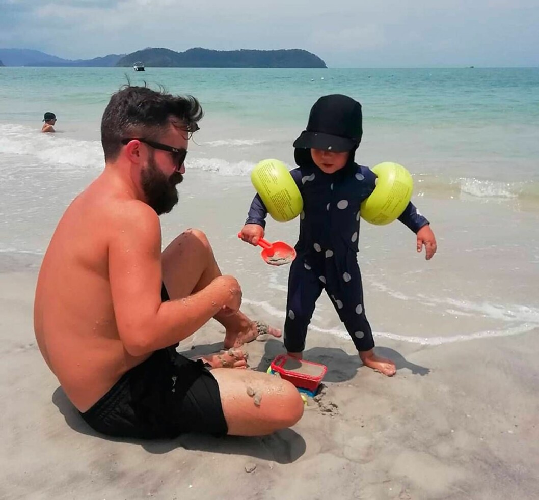 Robin och Henry leker på stranden Pantai Chenang Lankawi i Malaysia.