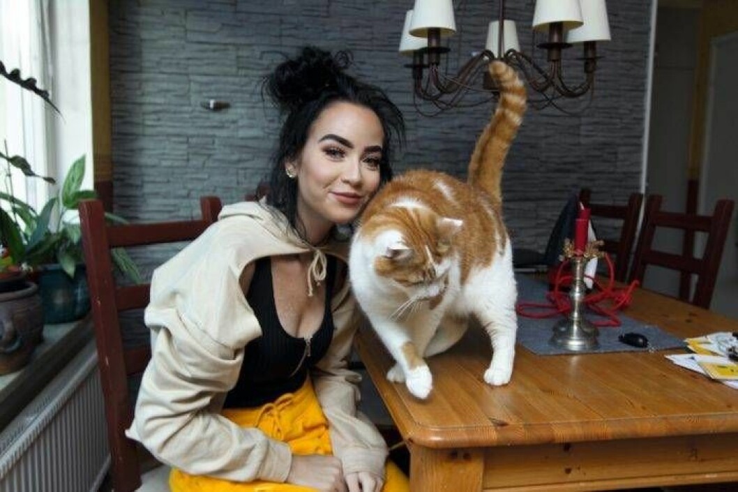 Olivia hemma med en av sina två katter. Olivia hemma vid köksbordet med en av sina två katter.