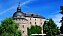 Örebro slott en blå sommardag. Slottet är rustikt i sten och har två kupoler.