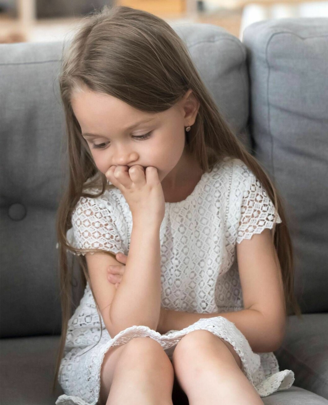 Annelie bor nästan tjugo mil ifrån sitt barnbarn och kan bara träffa henne ett par gånger i månaden. Men hon bär på en ständig oro över hur Lisa har det. En liten flicka sitter på en soffa och ser ledsen ut.