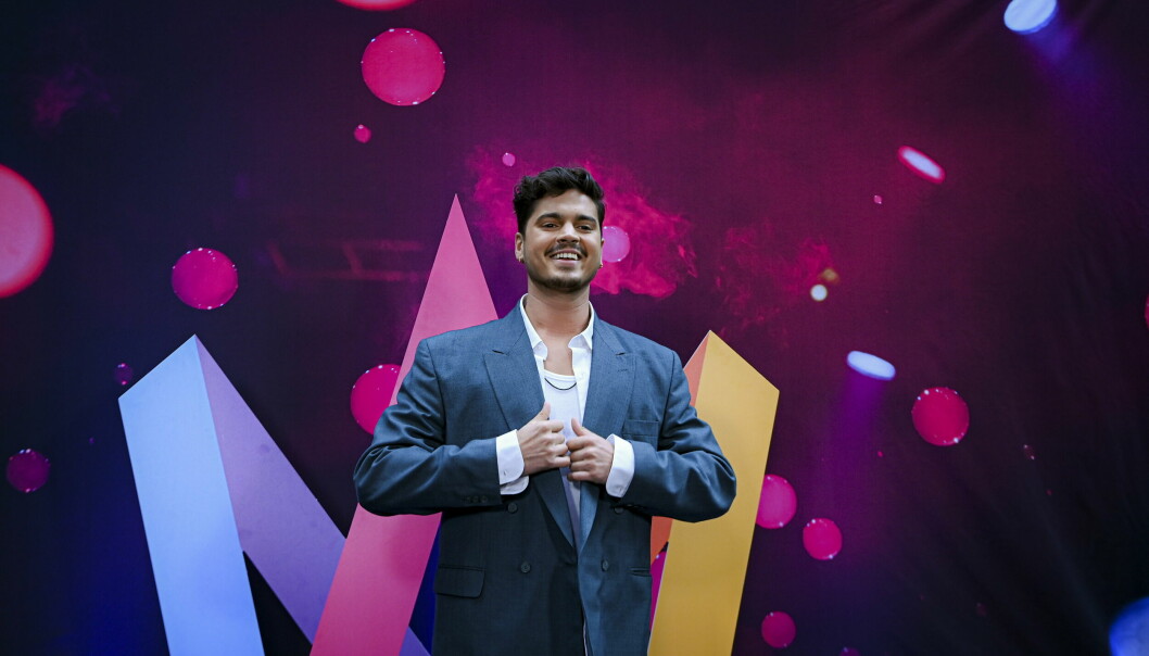 Oscar Zia framför Melodifestivalens logga.