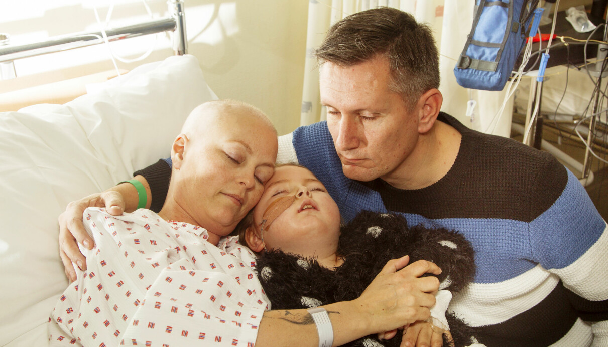 Ove, hustrun Pernille och dottern Anne håller om varandra i en sjukhussäng där Pernille och Anne behandlas för sin respektive cancer.