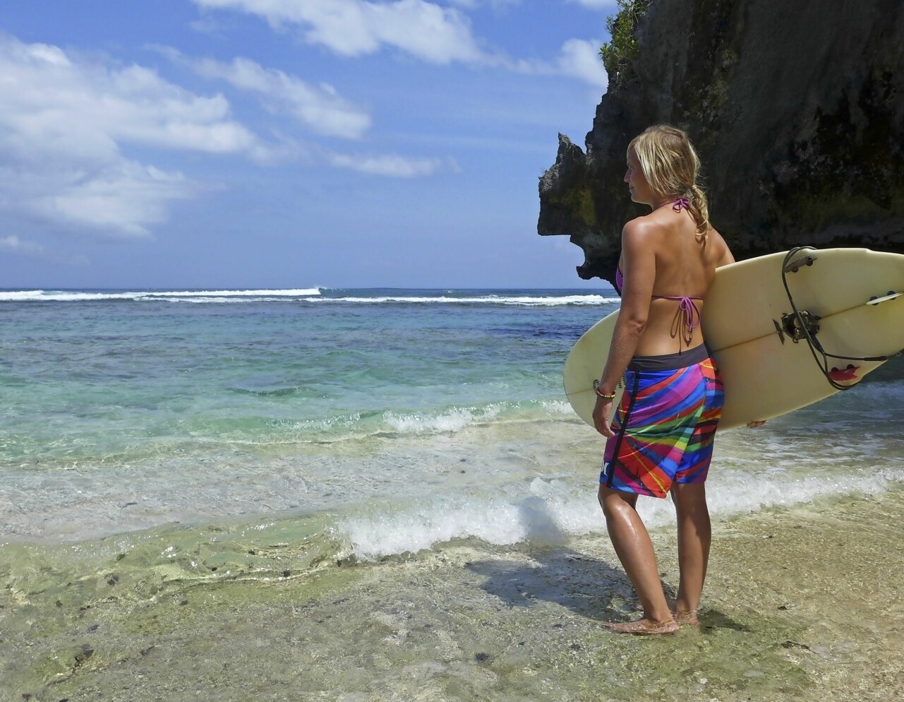 Höst betyder surfing i Portugal. Foto: Privat Johanna, som lever som modern nomad, med surfingbräda på en strand i Portugal.