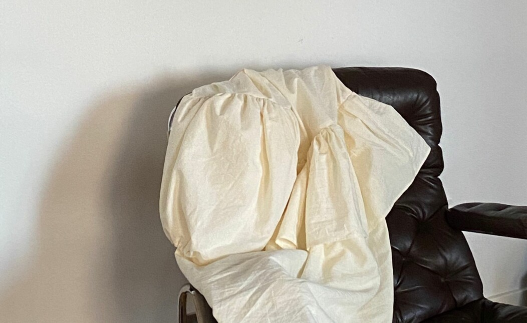 Den senaste favoritfärgen heter kort och gott ”smör”. På en svart skinnfåtölj hänger en glänsande, smörfärgad klänning med ballongärm och volanger.
