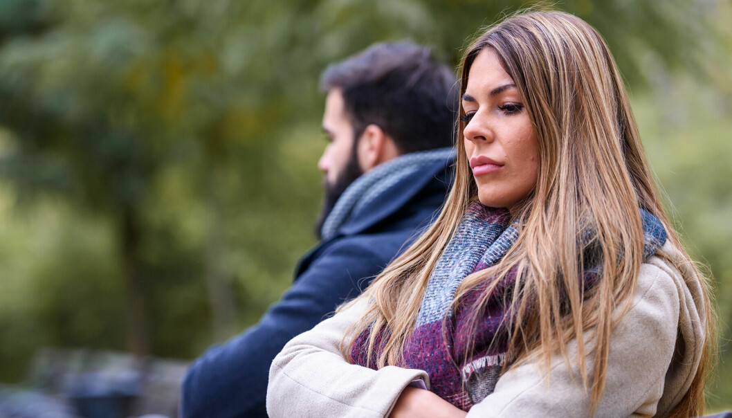 Man och kvinna i 30-årsåldern sitter med ryggarna mot varandra är ledsna.