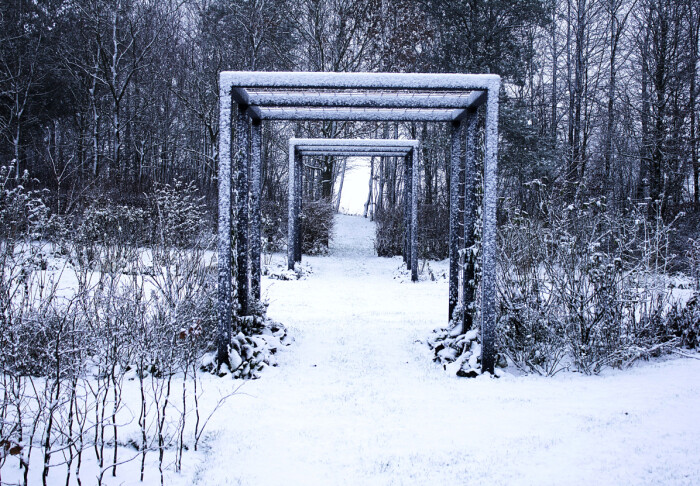 Den vackra gången genom flera pergolor och häcken fram till den lilla skogen är extra markerad en vinterdag med snö. Den vackra gången genom flera pergolor och häcken fram till den lilla skogen är extra markerad en vinterdag med snö.