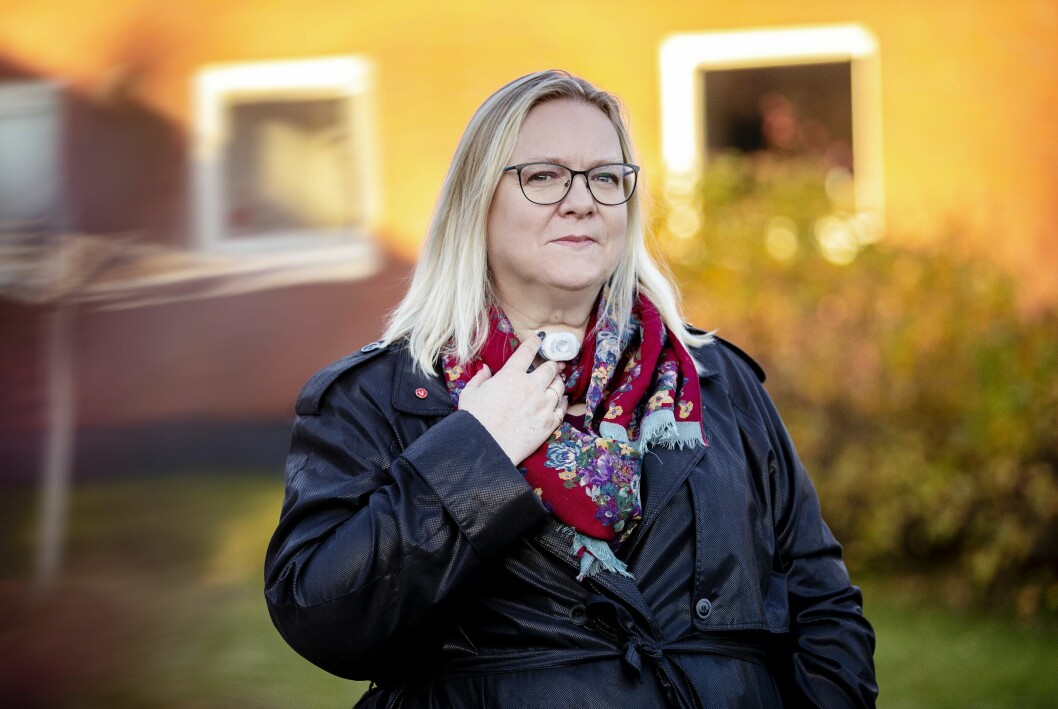 Petra Hall är ute trädgården där hon står och håller handen mot tuben hon har i halsen.