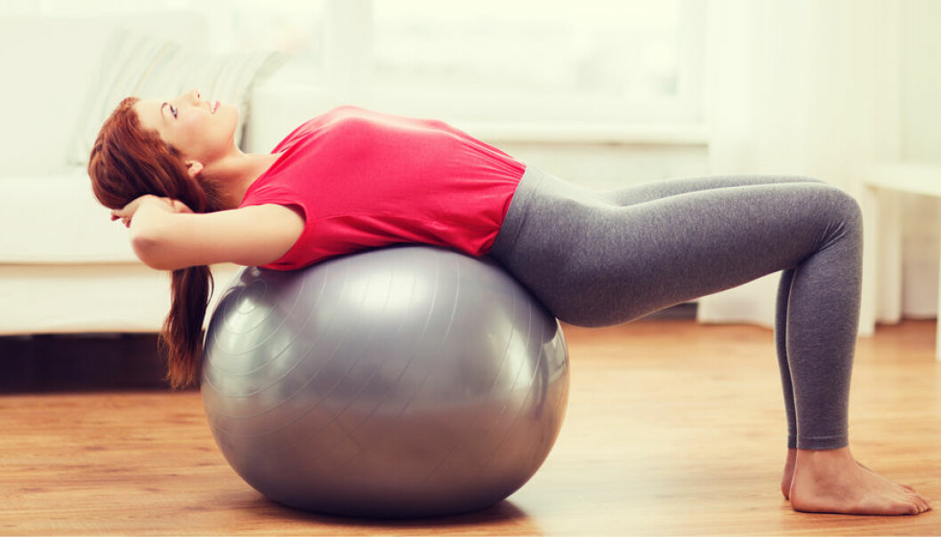 En kvinna övar på pilatesboll