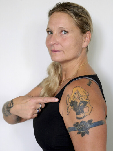 Jenny är noga med att betona att kvinnor som misshandlas inte är svaga. Foto: Joi Grinde Polisen Jenny, som misshandlades av sin partner, pekar på en tatuering av en stark kvinna.