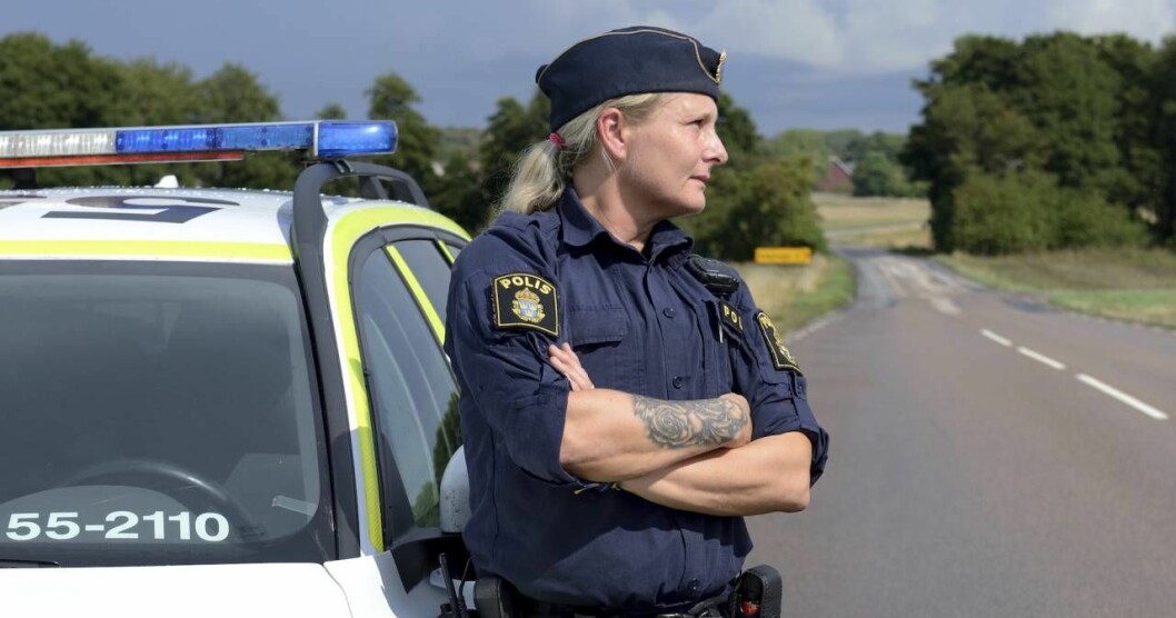 Jenny har lyckats behålla sin positiva livssyn – trots allt hon har varit med om och trots den ofta tuffa vardagen som polis. Foto: Joi Grinde Polisen jenny svenningsson står utanför en polisbil