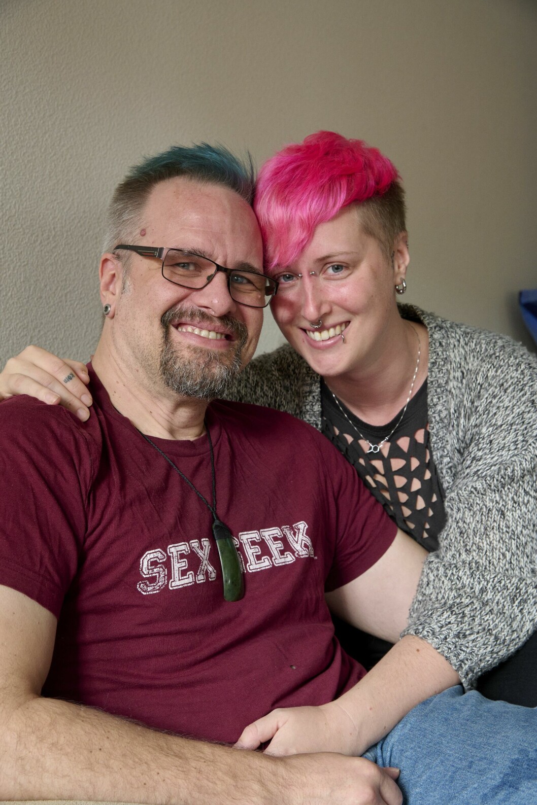 Att de även kan ha andra partner – det känner Anna och Patrik överlag är något positivt för deras förhållande. De älskar inte varandra mindre för det, tvärtom, menar paret. Patrik, med blå lugg, och Anna, med rosa lugg, sitter tätt ihop hemma i soffan.