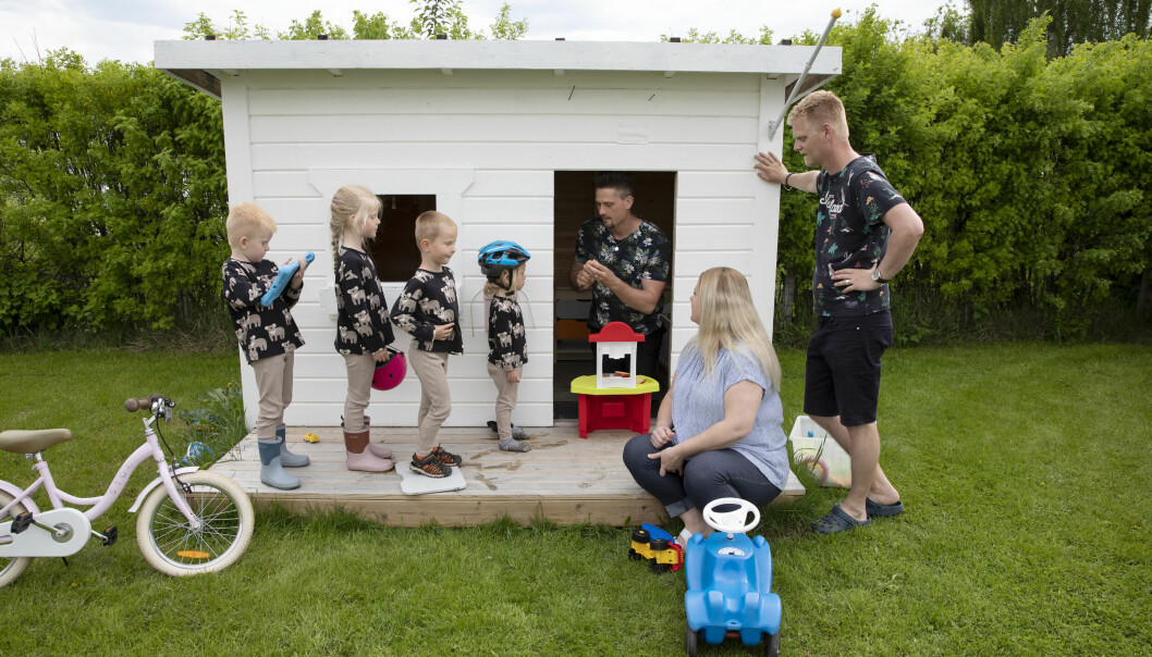 Sedan trion valde att leva ihop har familjen utökats med ytterligare fyra barn, minstingarna Nils, Signe, Birk och Ture. Hampus Engström sitter i en vitmålad lekstuga och leker med sina fyra barn som står uppradade utanför. Bredvid sitter Linda Fridland och Erik Fridland lutar sig mot lekhusets vägg.