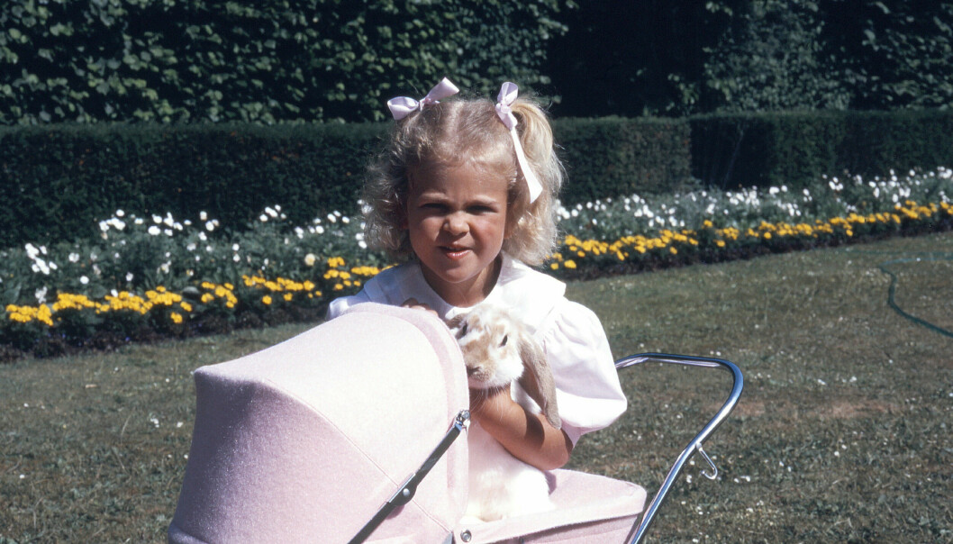 Prinsessan Madeleine håller om sin kanin Snuffe medan hon leker med en barnvagn på Solliden på Öland 1986. Prinsessan Madeleine 4 år