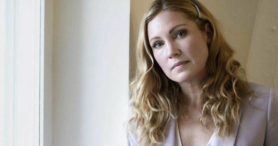 Jessica Almenäs tycker att tabun kring terapi och psykisk ohälsa har lättat sen hon för 20 år sedan behövde hjälp för första gången. Foto: Mickan Palmqvist / TT Jessica Almenäs ser ledsen ut framför en balkongdörr eller fönster.