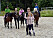 Erika står med barn och hästar och tittar in i kameran