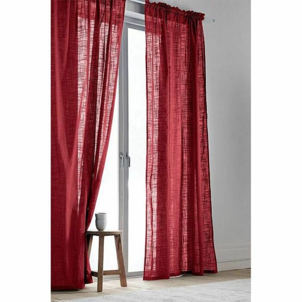 Röd gardin i ekologisk bomull från Jotex. <a href="http://www.awin1.com/cread.php?awinaffid=439053&awinmid=9961&clickref=gardiner&p=https%3A%2F%2Fwww.jotex.se%2Fhilda%2Fhilda-kanallangd-2-pack-ekologisk%2F1039195-08" target="_blank" rel="noopener">Här kan du läsa mer och köpa dem</a>. Röda svagt genomskinliga gardiner