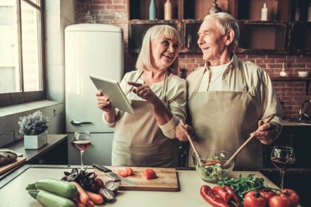 Foto: Shutterstock/IBL Äldre man och kvinna lagar mat i köket