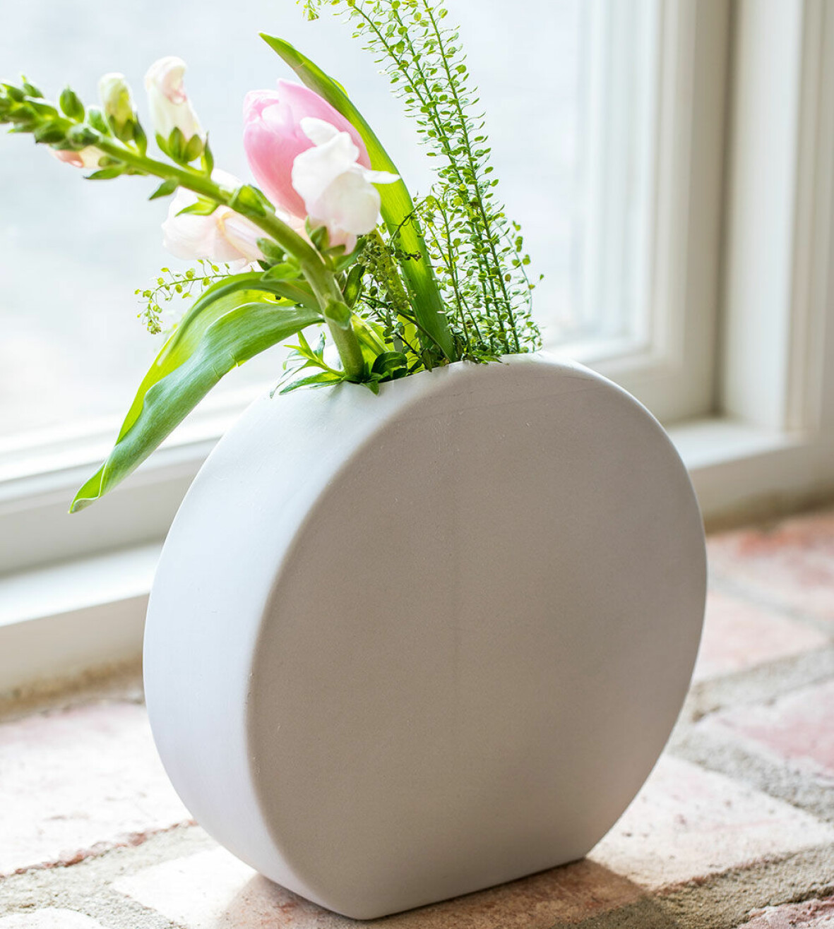 Rund vas med blommor i.