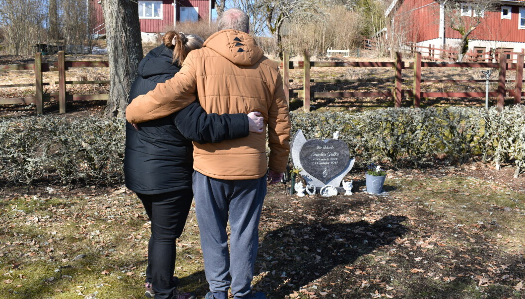 Föräldrarna håller om varandra vid Sandras grav.