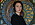 Sandra Lundberg i Ljungskile står framför en detaljrik tavla hon själv har målat. Hon har kort svart hår och är klädd i svart tröja.