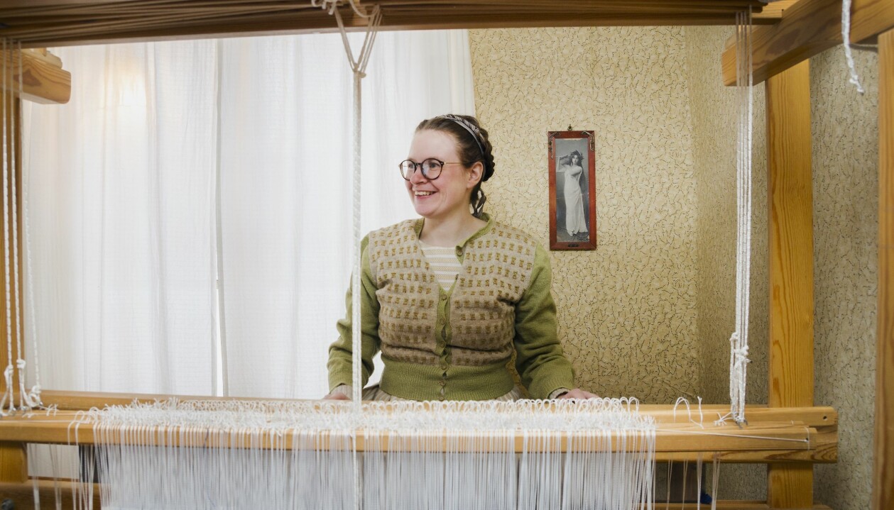 Här väver Sara Kånåhols ett tyg i halvylle som ska bli till bärsjalar. Sara är yrkesvävare och sitter vid en av sina vävstolar.