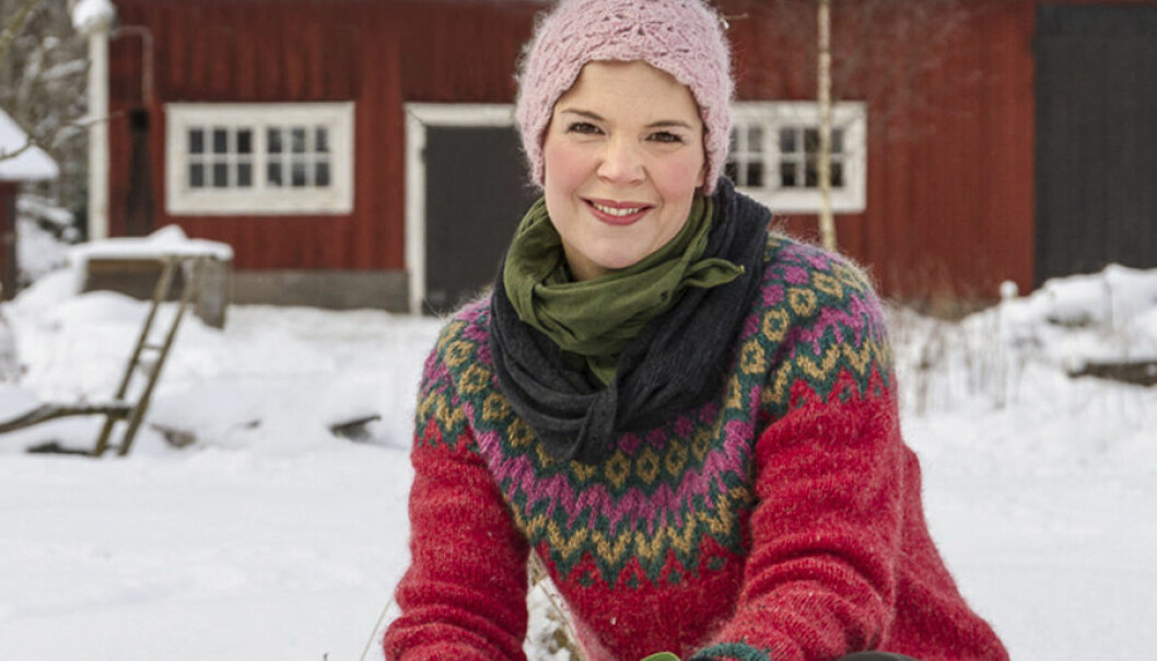 Sara Bäckmo I vinterlandskap framför rött hus.