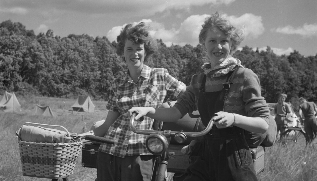 Två tjejer 1951 med cyklar och tält i bakgrunden.