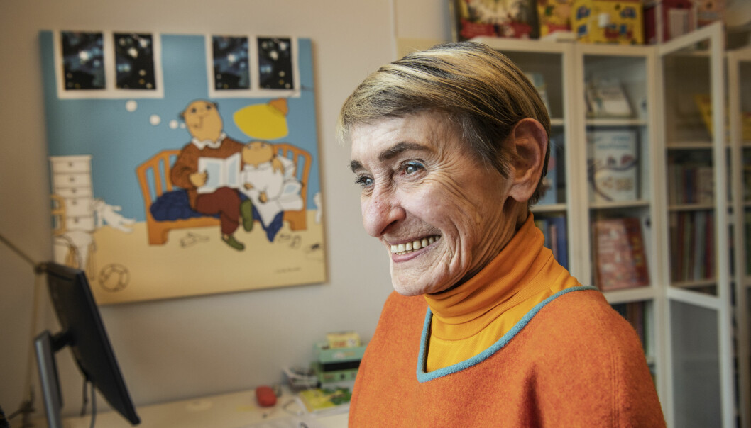 Gunilla Bergström ler i profil med Alfons Åberg-tavla i bakgrunden.