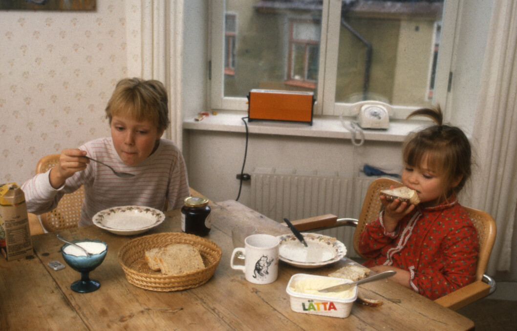 Två barn äter limpmacka med fil.