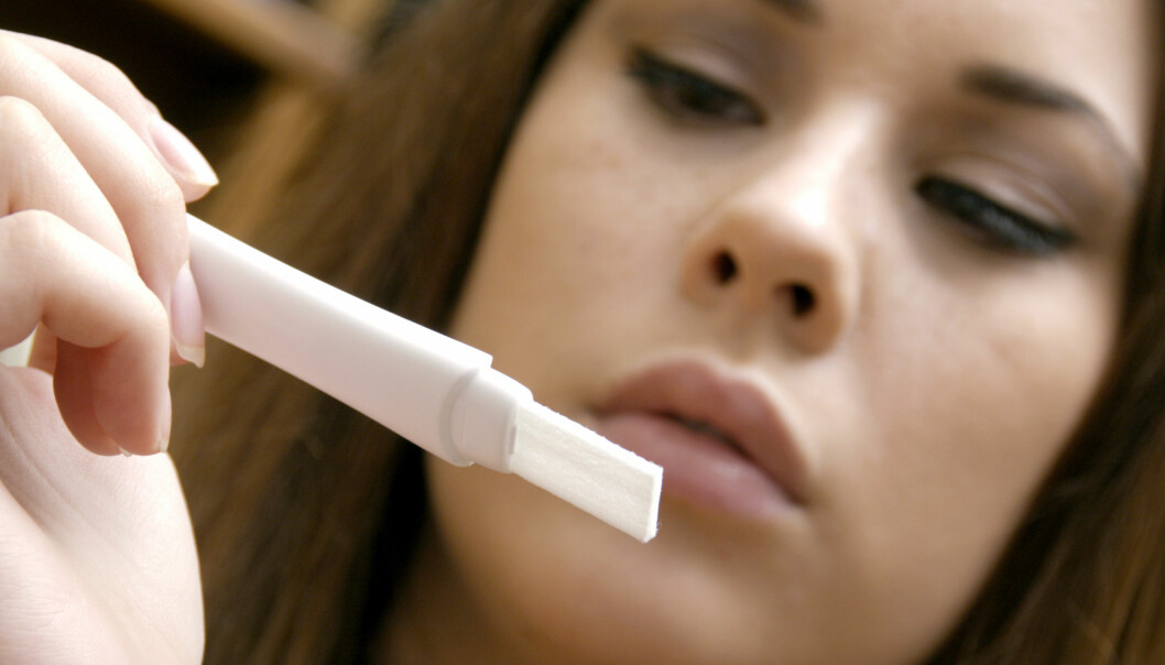 En kvinna försöker se resultatet på ett graviditetstest.